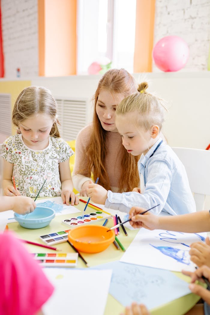 Kids and teacher enjoying a vibrant art activity in a classroom setting.